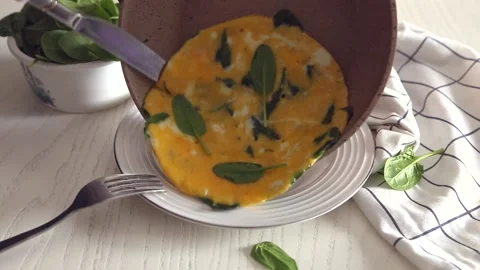 Egg omelet with spinach and cheese on a white plate Stock Footage 147732309