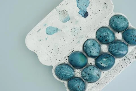 Egg packaging with painted easter eggs on blue background with space for text Stock Photos