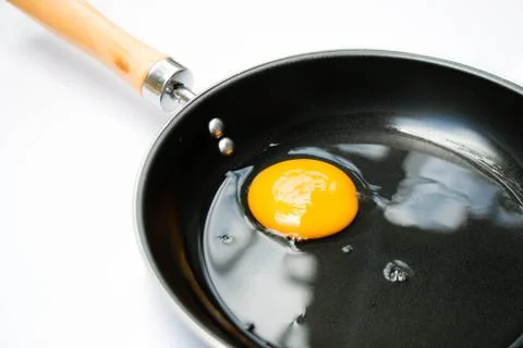 Egg in pan on white background Stock Photos