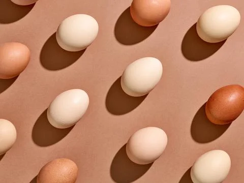 Egg pattern with hard shadow on brown background, from above Stock Photos