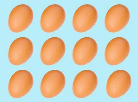 Egg pattern: raw chicken eggs on a purple background, one broken egg. Top vie Stock Photos