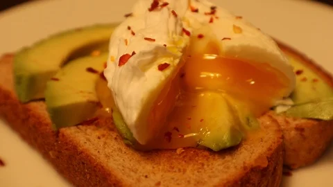 Egg Poached on Avocado Toast Fork Taking Bite from Shot Stock-Footage 127260588