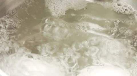 An egg in a pot of boiling water and a kitchen timer Stock Footage 24635821