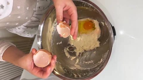 Egg is put into the metal dish Stock Footage 230078050