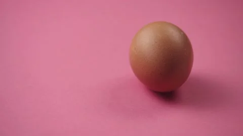 Egg rotates on pink background. Fresh, organic and healthy chicken egg. Stockbeeldmateriaal 181164706