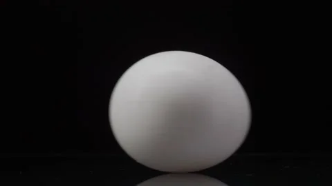Egg rotation. White chicken egg spinning on a black background with reflection Stock-Footage 147407382