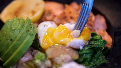 Egg with runny yolk Poached egg cut in half and runny yolk flow down on sandwich Stock Footage 293337923