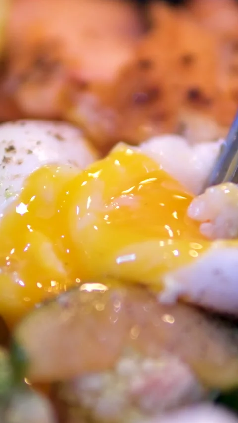 Egg with runny yolk Poached egg cut in half and runny yolk flow down on sandwich Stock Footage 293642721