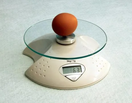 Egg on scales Stock Photos