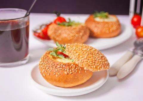 Egg served in bread bowl. Breakfast baked eggs in bread bowls with the fresh  Stock Photos