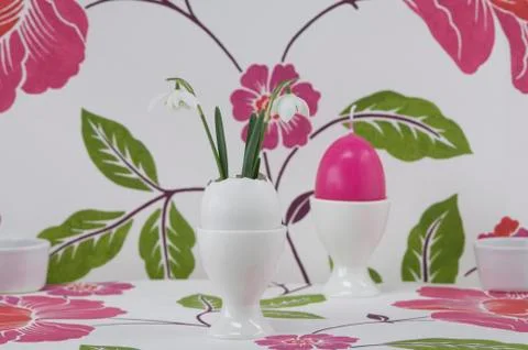 Egg shape candle in egg cup and snowdrop in eggshell, close up Stock Photos
