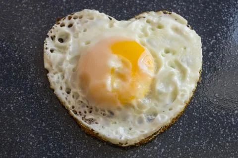 Egg in the shape of heart. Stock Photos