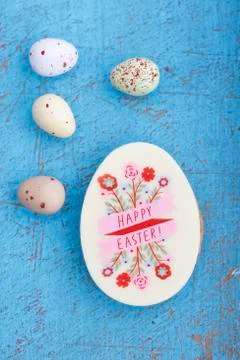 An egg-shaped Easter biscuit decorated with writing and sugar quail's eggs Stock Photos