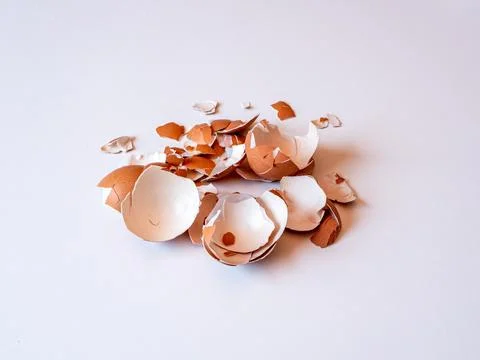 Egg shells are scattered on a flat surface in a kitchen Stock Photos