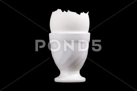 Egg shells in cup isolated over black background Stock Photos