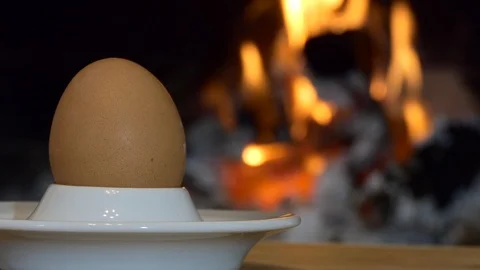 Egg. Simple meal. The egg lies on a stand against the firelight. Video stock 123576983