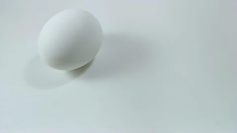 Egg spinning and rolling on the white table Easter egg Stock Footage 104671716