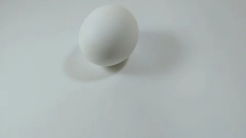Egg spinning and rolling on the white table Easter egg Video stock 104671800
