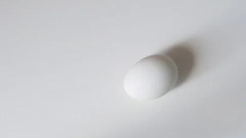 Egg spinning.Chicken egg spinning on white background top view. Egg spinning and Stock Footage 107959974