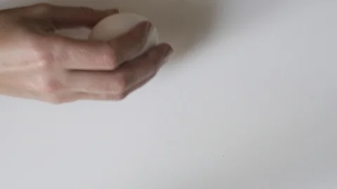 Egg spinning.Chicken egg spinning on white background top view. Egg spinning and Stock-Footage 107960132