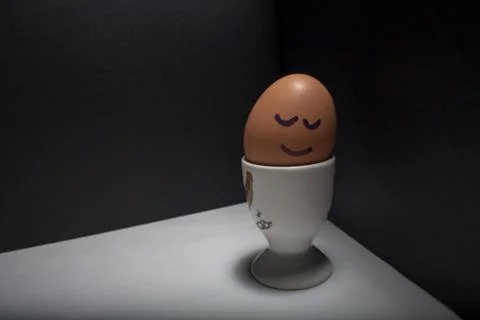 Egg standing on egg cup, isolated on white background Stock Photos