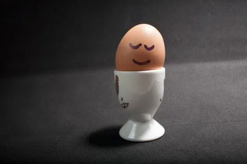 Egg standing on egg cup, isolated on white background Stock Photos