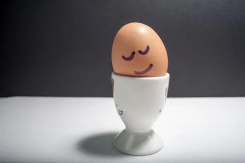 Egg standing on egg cup, isolated on white background Stock Photos