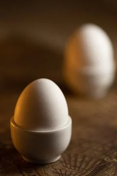 Egg standing on egg cup. Two cooked organic eggs for breakfast. Stock Photos