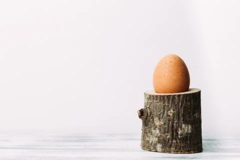 Egg standing on rustic wooden egg cup 스톡 사진