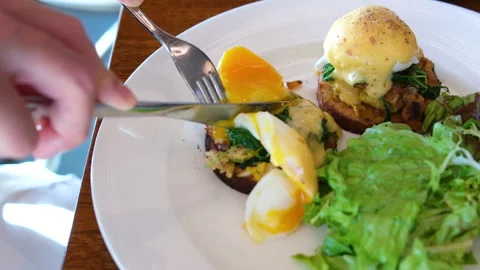 Egg steak spinach Person enjoying healthy breakfast with eggs Benedict, salad Stock Footage 313809604