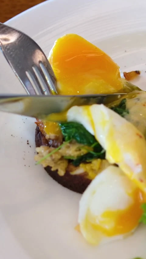 Egg steak spinach Person enjoying healthy breakfast with eggs Benedict, salad Stock Footage 314344399