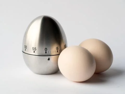 Egg timer and eggs Stock Photos