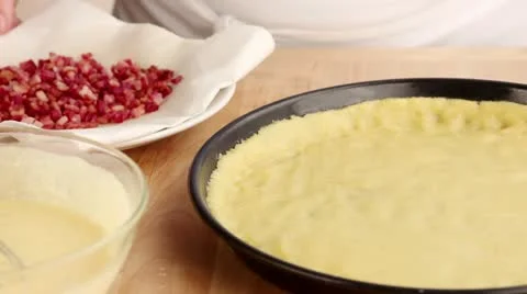 Egg topping being poured over diced bacon on a pastry base Stock Footage 24670139