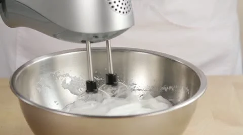 Egg white being beaten with a hand mixer Stock Footage 24653117
