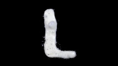 Egg white frying letter L, include two looped 10 seconds duration versions Stock Footage 130800842