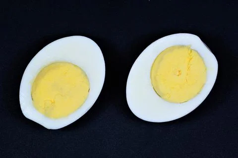 The egg is white, isolated on a black background. Stock Photos