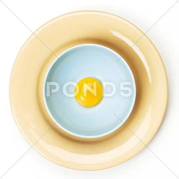 Egg Yolk in a Bowl on a Plate; From Above Stock Photos