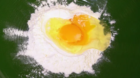 Egg yolk falling into flour, dough is made for making a pie Stock Footage 249444633