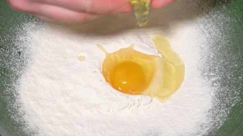 Egg yolk falling into flour Stock Footage 248983755