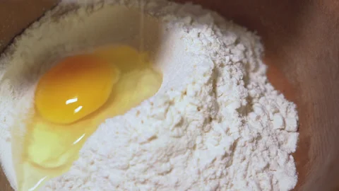 Egg yolk falling into flour Stock Footage 254166448