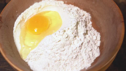 Egg yolk falling into flour Stock Footage 254166544