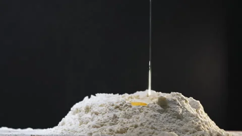 Egg with yolk falls down into hole in white flour on table 스톡 동영상 149810527
