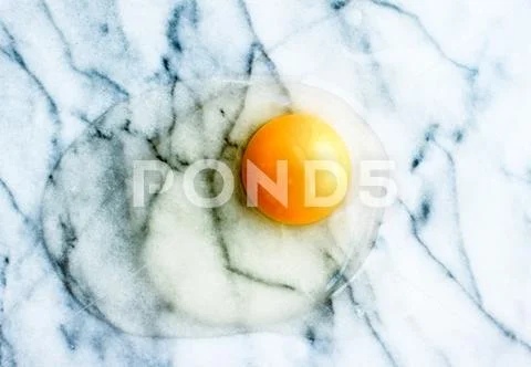 Egg yolk on marble - recipe ingredients and homemade cooking concept Stock Photos