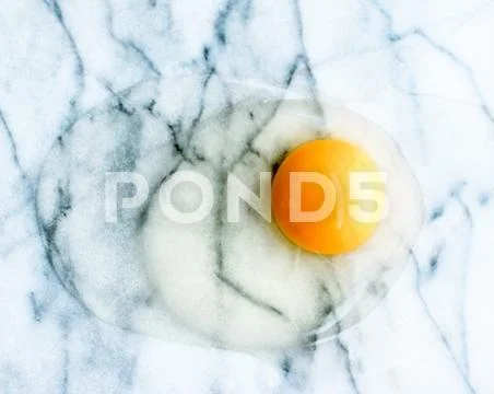 Egg yolk on marble - recipe ingredients and homemade cooking concept Stock Photos