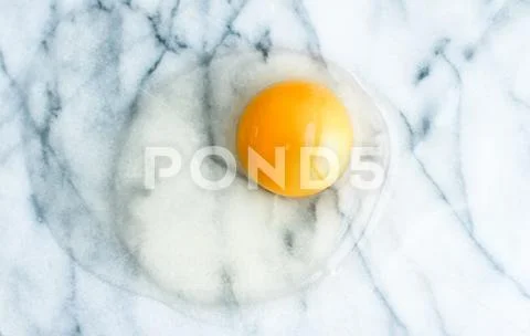 Egg yolk on marble - recipe ingredients and homemade cooking concept Stock Photos