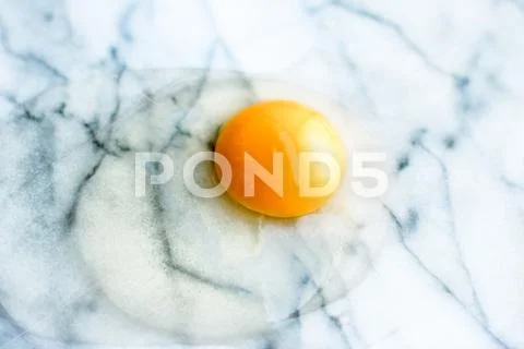 Egg yolk on marble - recipe ingredients and homemade cooking concept Stock Photos