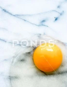 Egg yolk on marble - recipe ingredients and homemade cooking concept Stock Photos