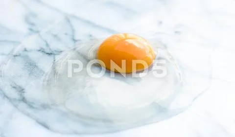 Egg yolk on marble - recipe ingredients and homemade cooking concept Stock Photos