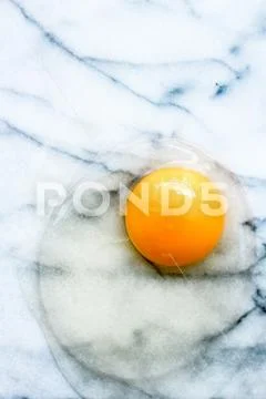 Egg yolk on marble - recipe ingredients and homemade cooking concept Stock Photos