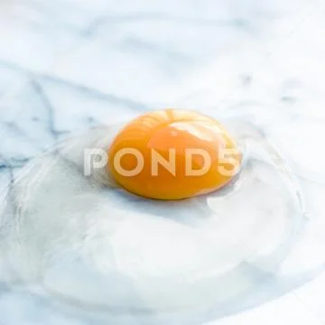 Egg yolk on marble - recipe ingredients and homemade cooking concept Stock Photos